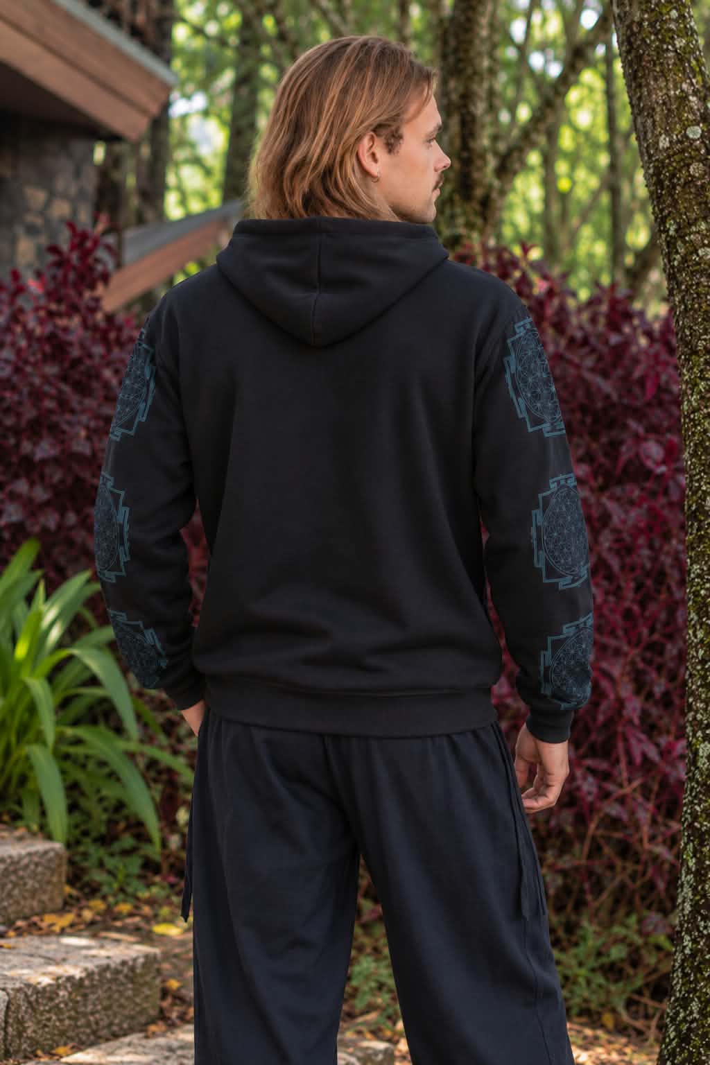 Back view of men’s black fleece-lined hoodie showing plain black back and blue geometric sleeve print