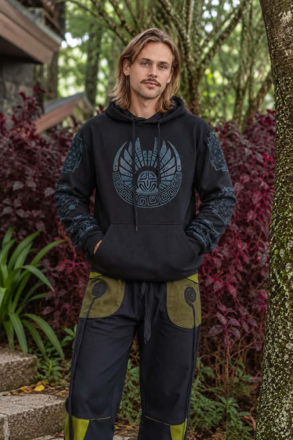 Men’s black fleece-lined hoodie with blue tribal geometric print on the front and sleeves, worn with harem pants