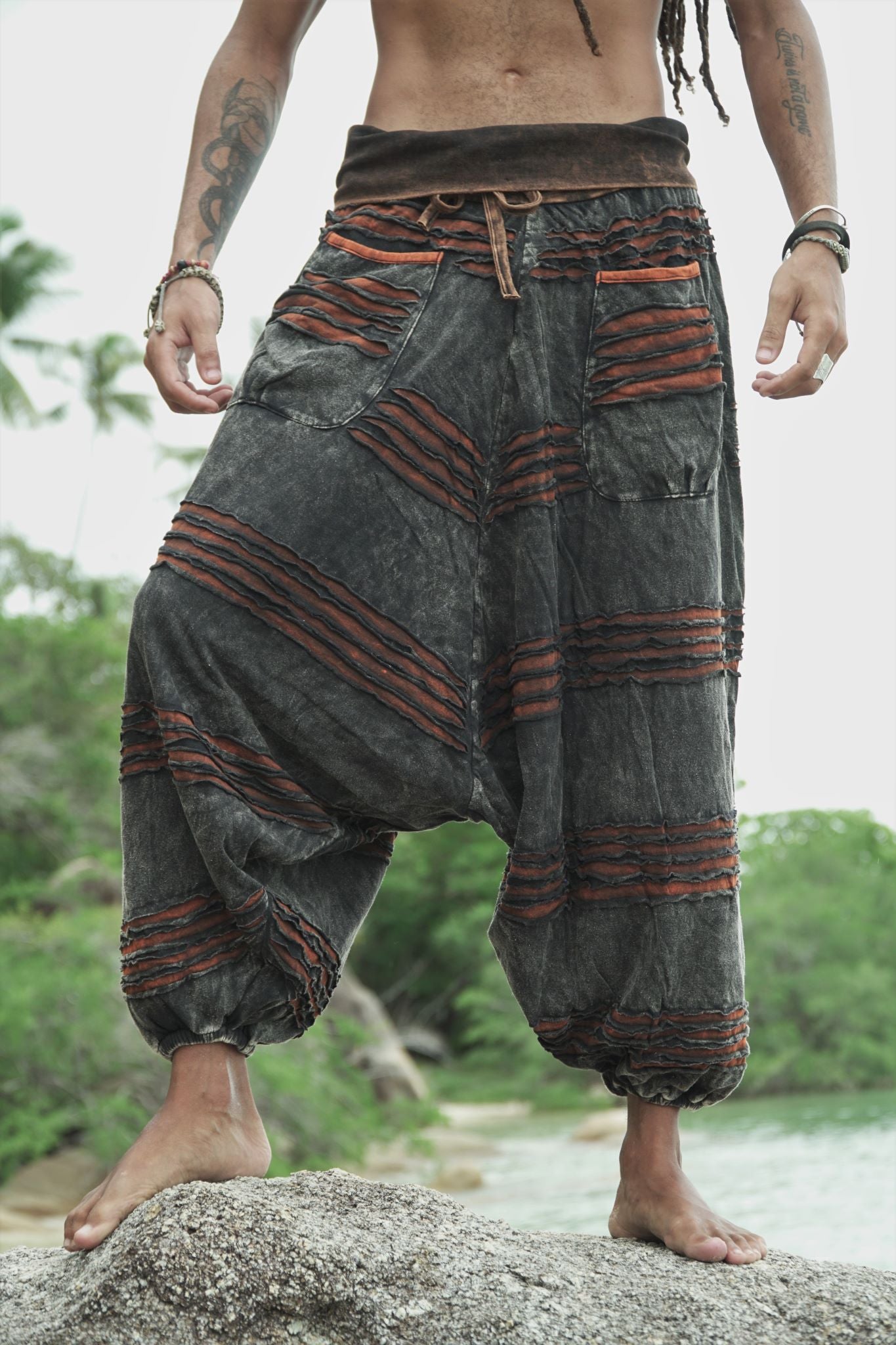 Front view of men's charcoal stonewashed razorcut harem pants with a rust orange underlayer, oversized pockets and elasticated ankles.