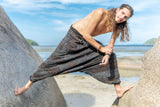 Men's charcoal grey stonewashed drop crotch trousers with handcrafted brown razorcut detailing, photographed on a model outdoors.