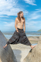 Front view of men's charcoal grey festival harem pants with a brown razorcut underlay, oversized pockets and elasticated ankles.