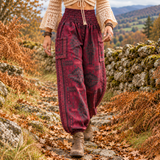 Woman in an autumn boho outfit wearing warm maroon patterned harem trousers made from soft vegan friendly fabric