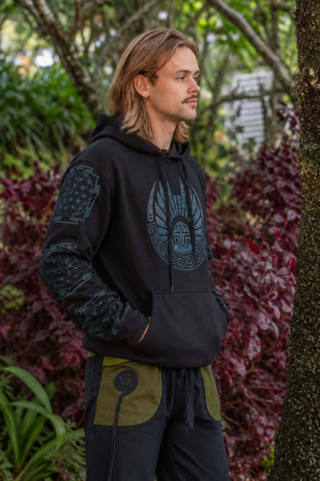 Side view of men’s black fleece-lined tribal hoodie with blue geometric chest and sleeve design
