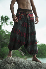 Man wearing charcoal grey razorcut festival trousers with a maroon underlayer, relaxed fit and handcrafted bohemian styling.