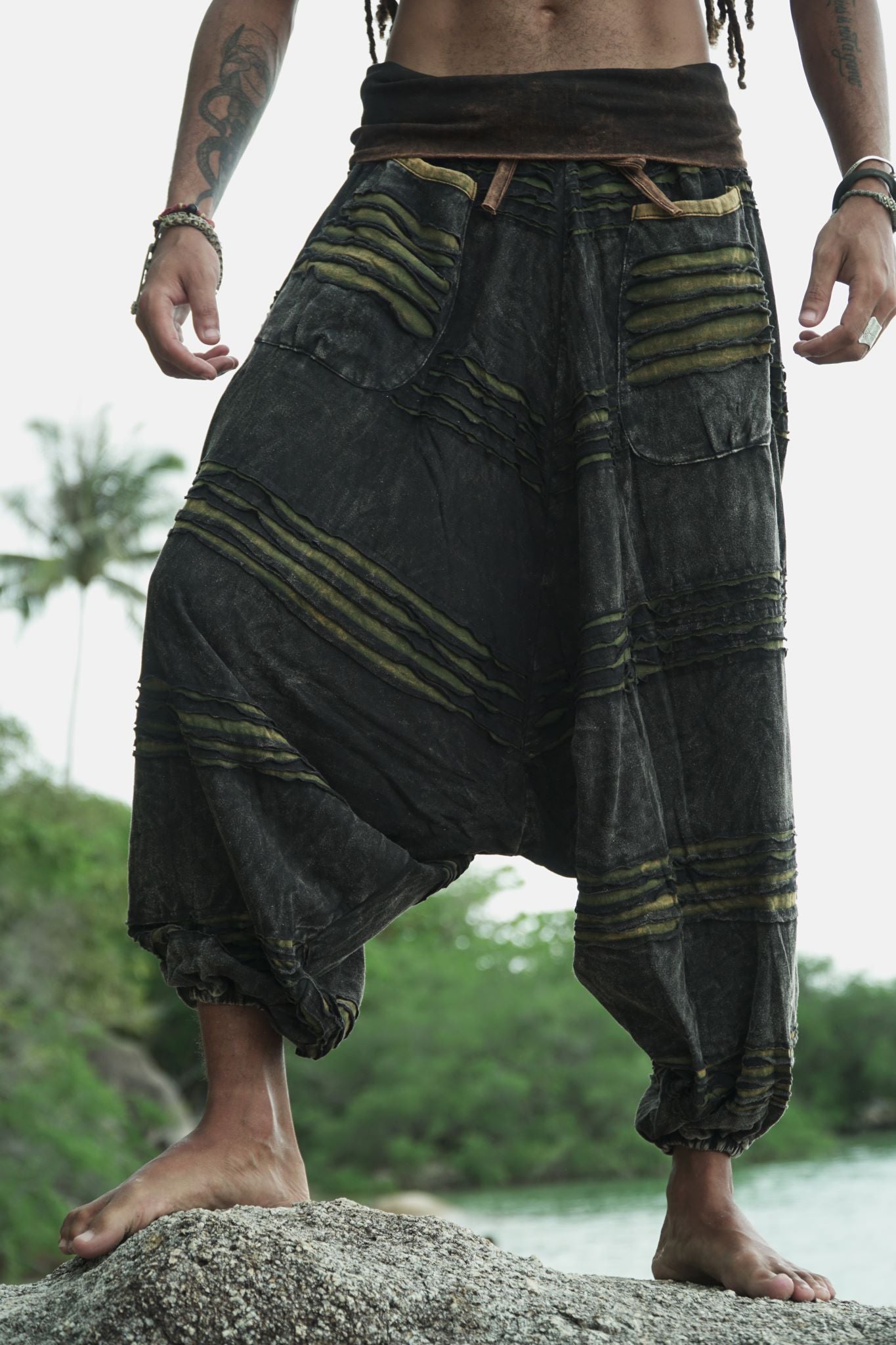 Front detail of men's charcoal stonewashed razorcut harem pants with a green underlayer, showing the waistband, razorcut texture and relaxed fit.