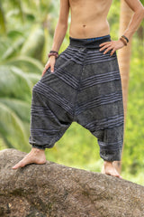 Detailed front view of grey stonewashed cotton men's drop crotch trousers, highlighting the handcrafted razorcut design, textured fabric and relaxed boho fit.