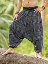 Front view of a man wearing grey stonewashed cotton razorcut harem pants with a relaxed drop crotch fit, layered razorcut detailing and elasticated waistband and cuffs.