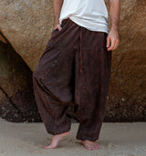 Front detail of men's brown stonewashed drop crotch harem pants, boho festival style