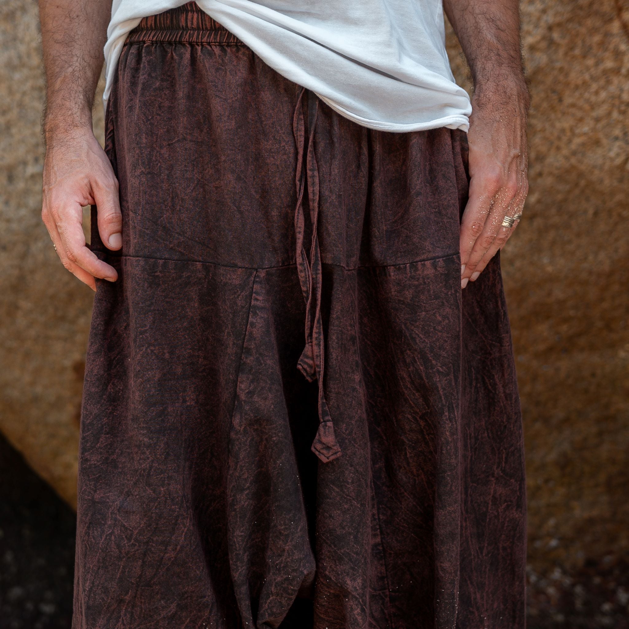 Drawstring waistband detail on men's brown stonewashed drop crotch harem pants