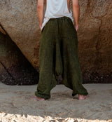 Men's khaki green stonewashed drop crotch harem pants, full length back view on beach