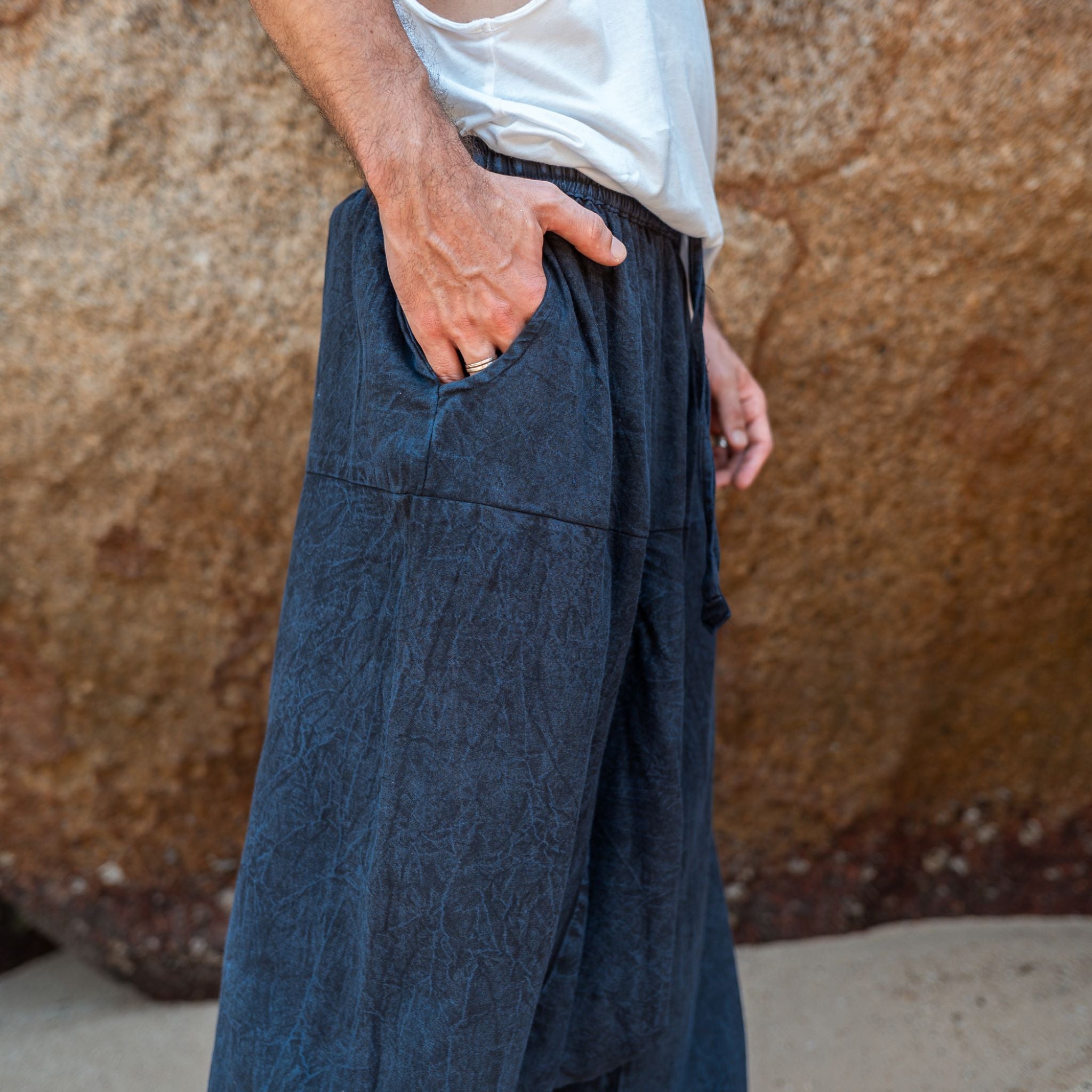 Side pocket detail on men's navy stonewashed drop crotch harem pants, relaxed boho fit
