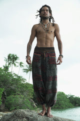 Front view of charcoal grey stonewashed boho trousers with a maroon razorcut underlay, relaxed drop crotch styling and elasticated ankles.