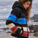 Close-up of women's charcoal wool jacket showing blue variegated knitting, cream panels, colourful hand stitching and zipped pockets.