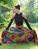 Women's multicolour bohemian patchwork harem pants in festival style, full length front view with wide flared legs and button waist detail