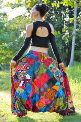 Back view of women's multicolour patchwork harem pants showing elasticated waistband and full patchwork fabric detail, held wide