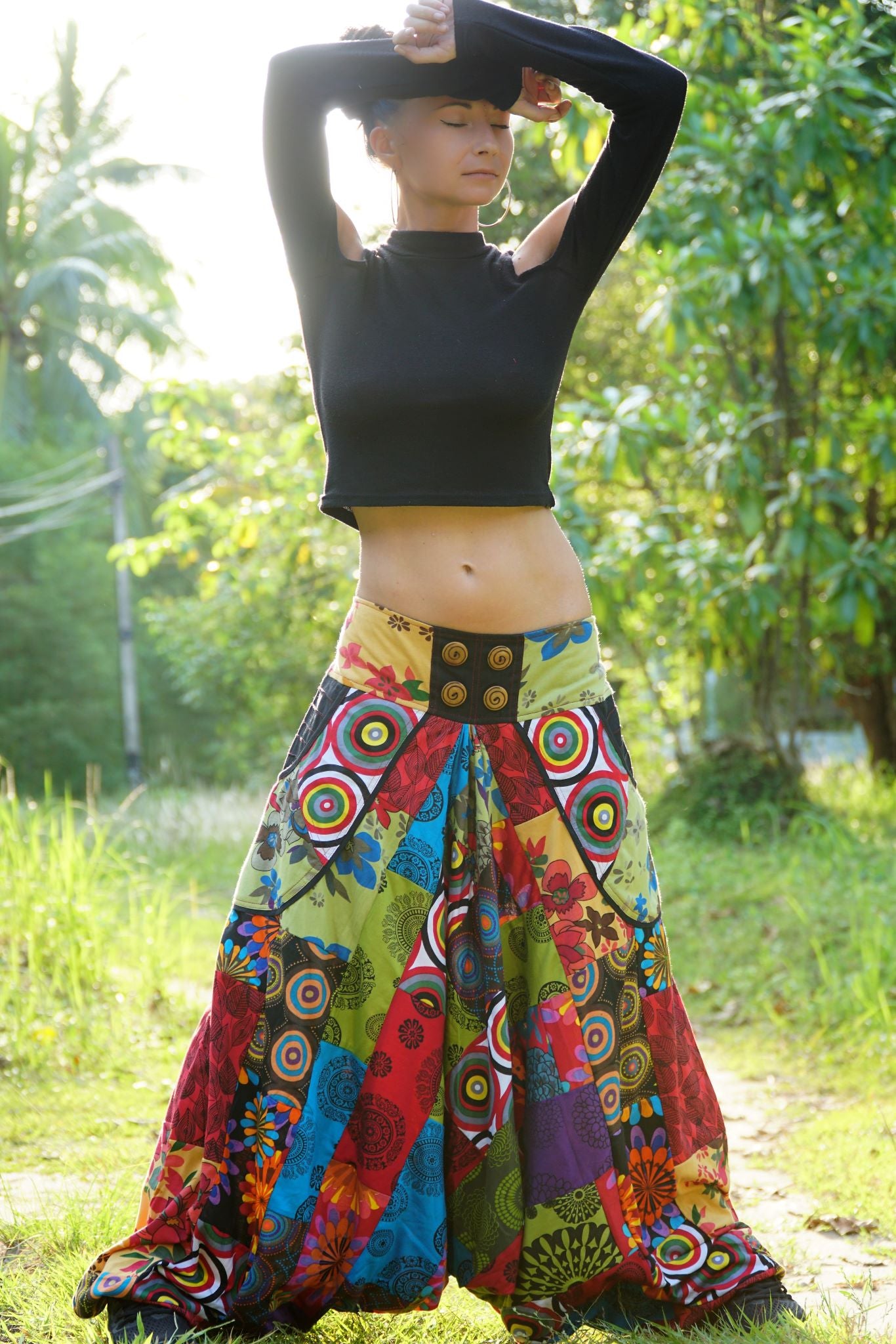 Women's multicolour patchwork harem pants, full length front view showing wide flared legs and decorative button waistband, worn outdoors