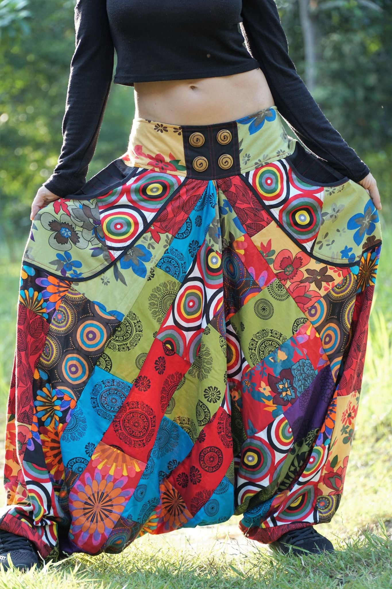 Detailed front view of women's wide leg patchwork harem pants showing rainbow mandala, floral and geometric print panels